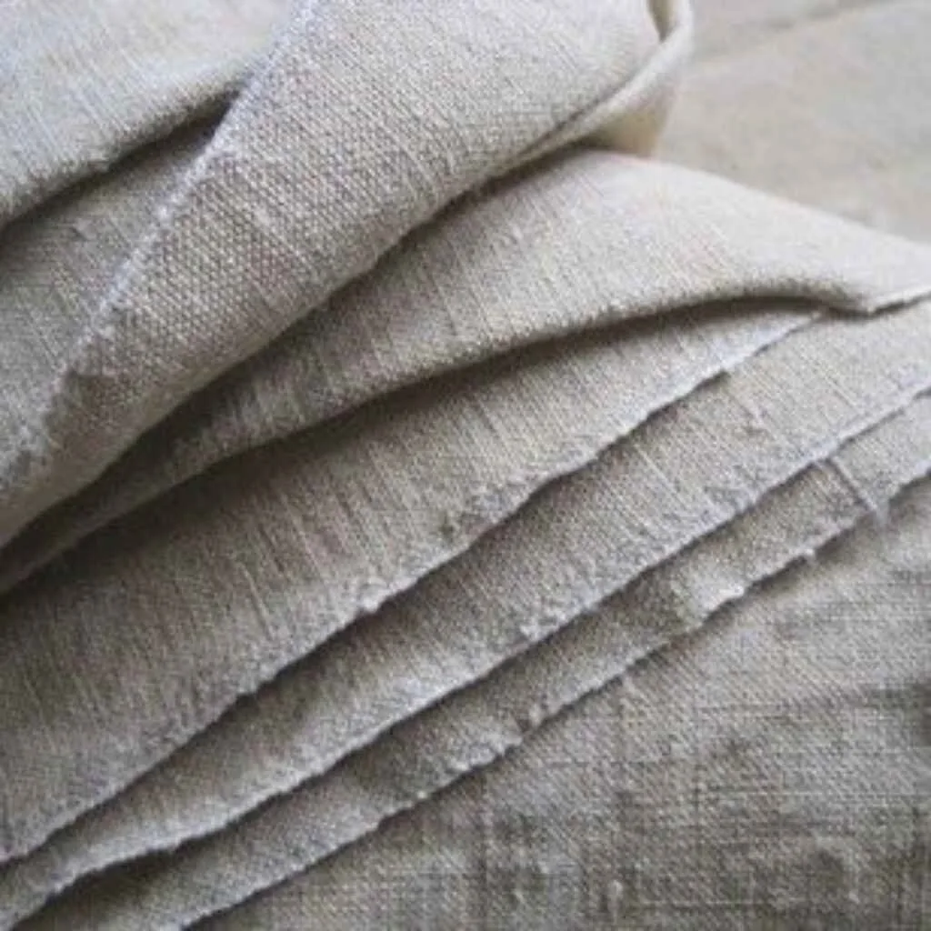 A close-up view of folded natural hemp fabric, showcasing its texture and durability.