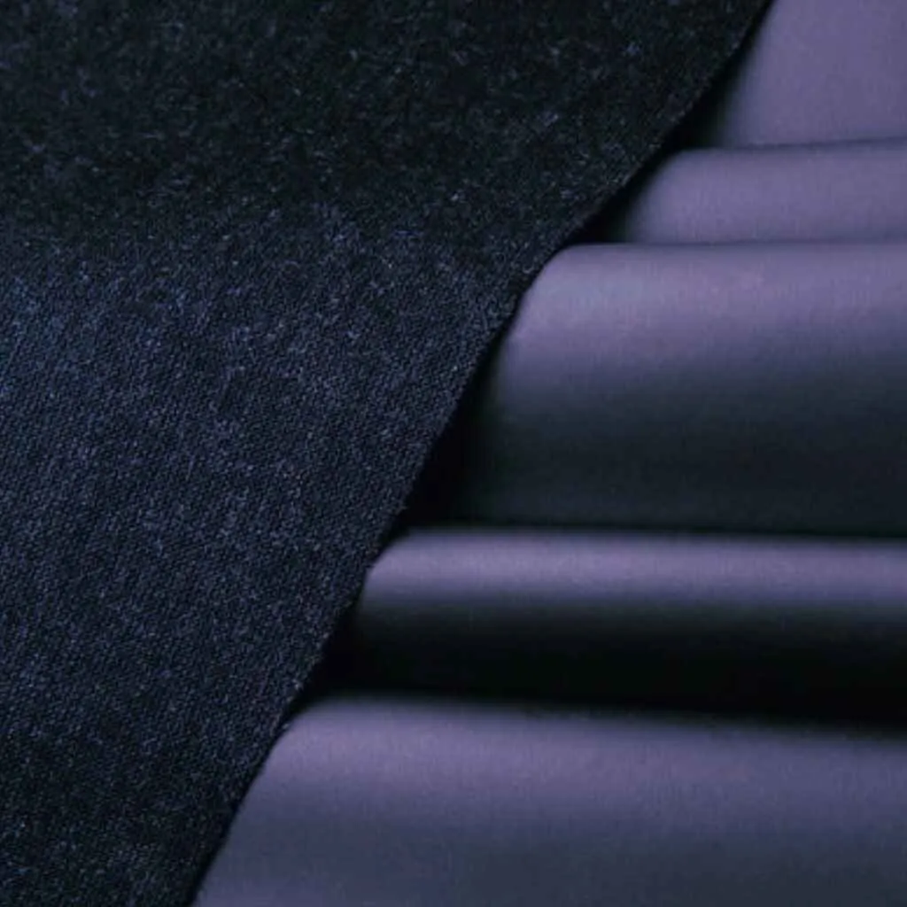 Close-up of dark Piñatax fabric, showcasing its innovative texture and smooth finish.