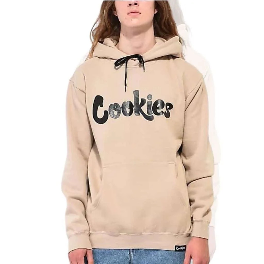  A young person wearing a beige hoodie with the word "Cookies" printed in bold letters on the front.