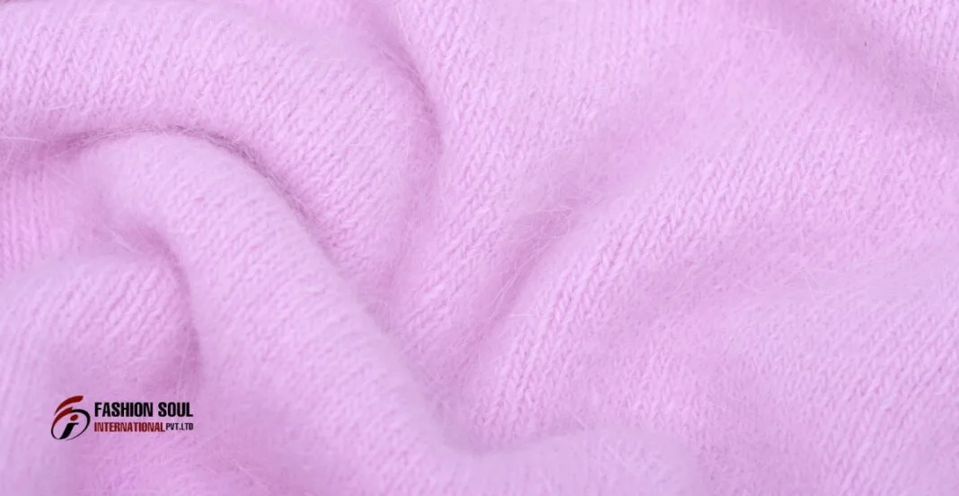 Close-up of soft, pink Angora wool fabric with a fluffy texture, featuring a subtle knit pattern.