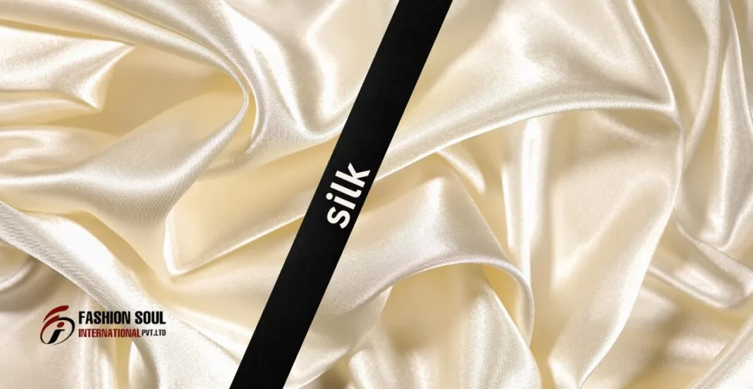 A close-up of smooth, creamy silk fabric, with a black label reading 