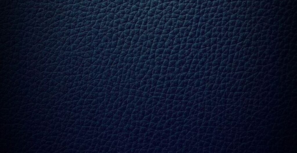 Close-up view of dark blue split leather texture, displaying a fine, crinkled pattern.
