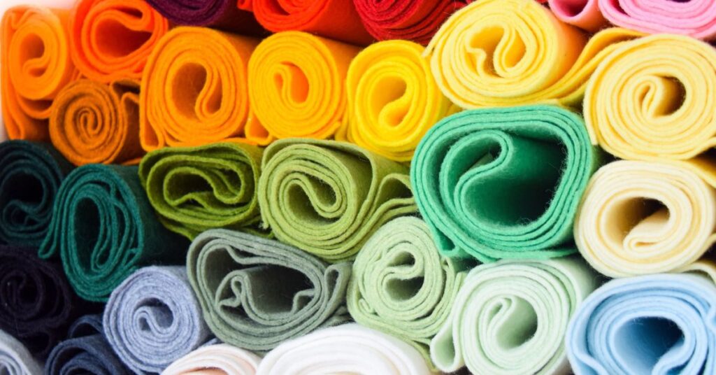Colorful rolled felt fabric pieces arranged in a neat pattern, showcasing soft texture and vibrant hues.