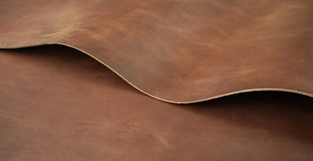 "Illustration showing the concept of flux leather, depicting smooth, flowing shapes morphing into a leather texture with a gradient background."