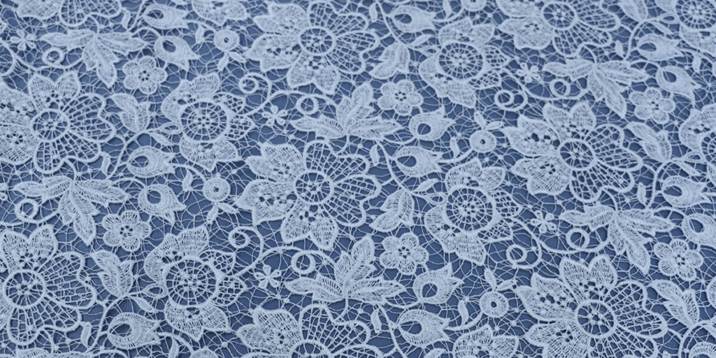 "Lace fabric with intricate floral patterns, showcasing its delicate texture and elegant design."