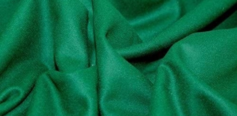 A close-up view of smooth green baize fabric, displaying soft folds and texture.
