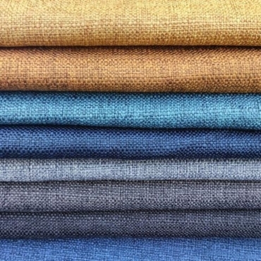 Stacked linon fabric in various colors, including shades of brown, teal, and blue.