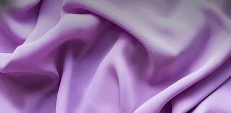 A close-up view of soft, draping lavender rayon fabric, showcasing its smooth texture and gentle folds.