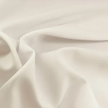 A close-up image of soft, luxurious light cream rayon fabric, displaying its smooth texture and drape. " rayon fabric shrink"