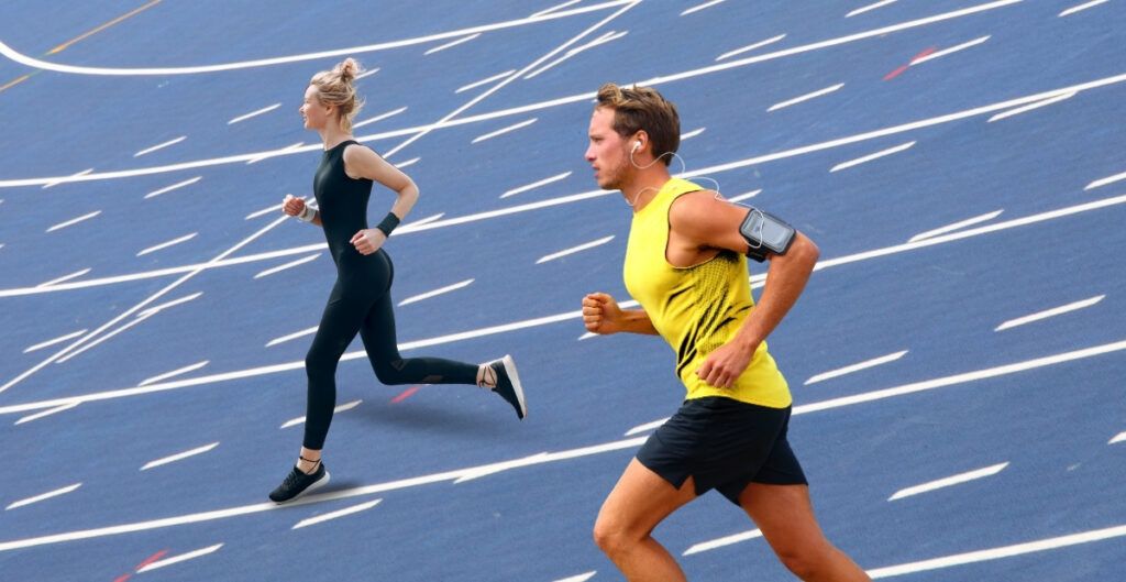A woman and a man running on a track. The woman wears a black athletic outfit, while the man is in a bright yellow tank top and black shorts. Both are wearing running shoes. top sportswear