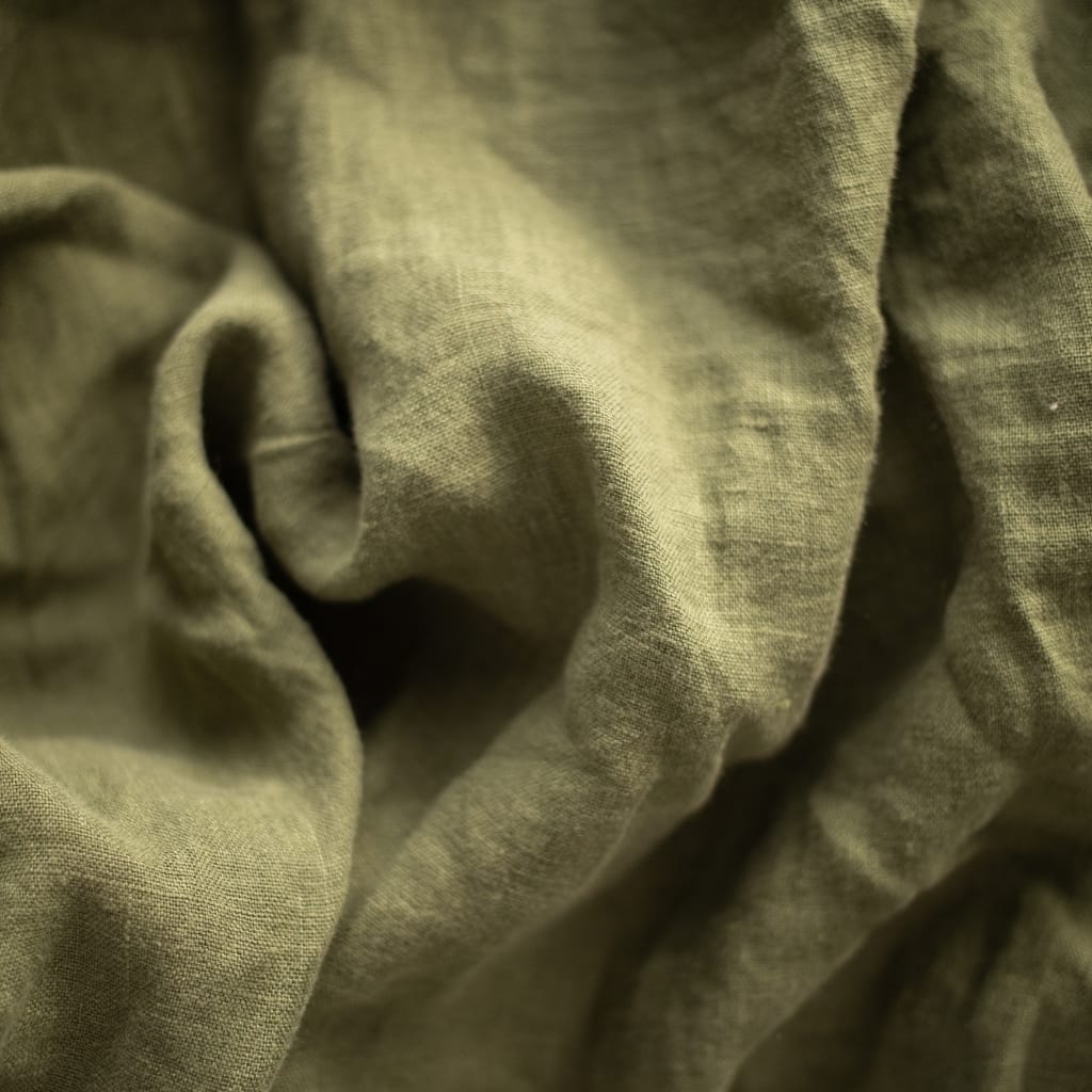 Close-up of olive-green fabric with a slightly wrinkled texture and soft folds.