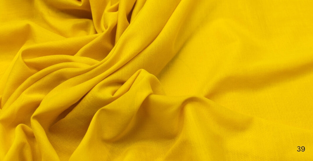 Bright yellow, semi-transparent cotton fabric with soft folds and gentle draping.