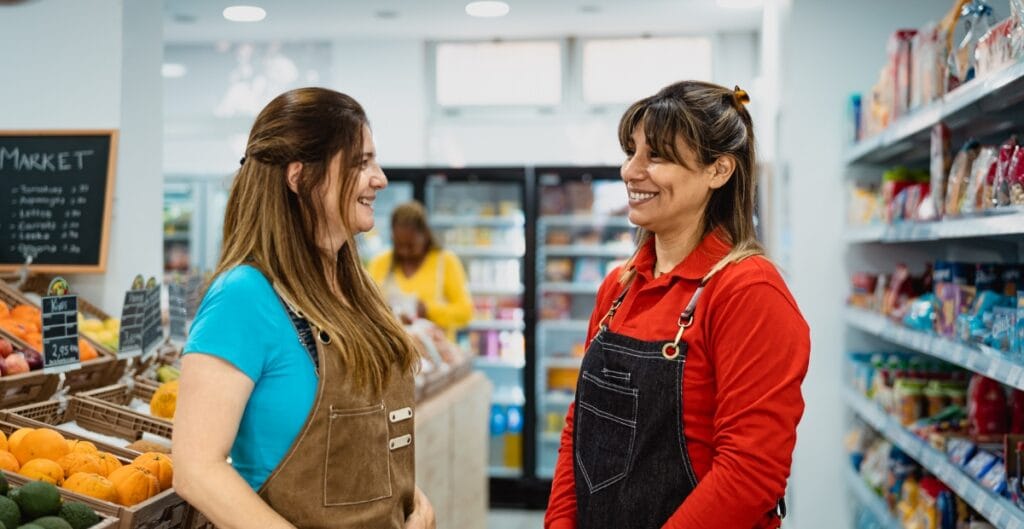 "Friendly shop staff assisting a customer with fabric recommendations at a local sewing store"