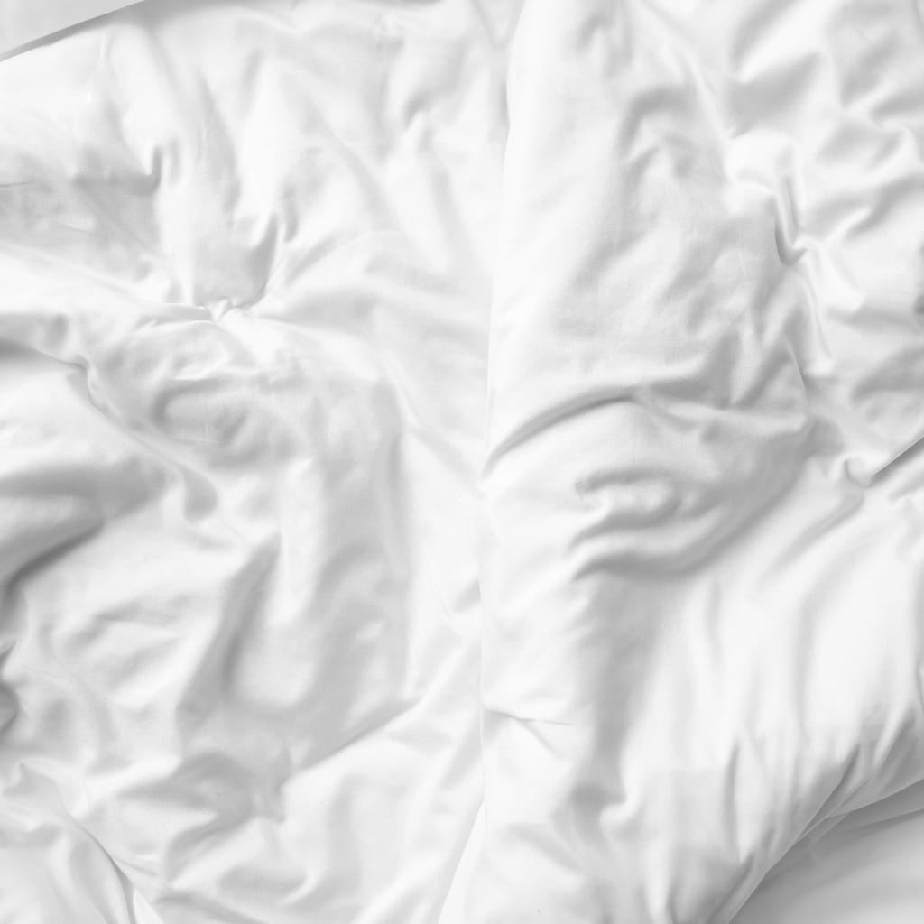 A close-up of white, wrinkled, silky-looking bedsheets with soft, natural folds.