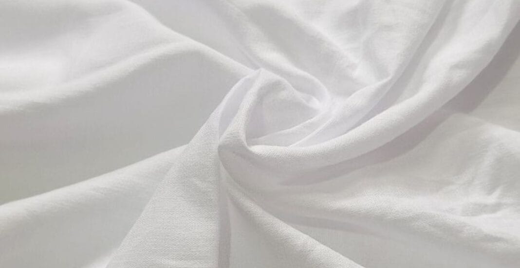 A close-up image of soft, white cotton fabric gently draped and twisted.