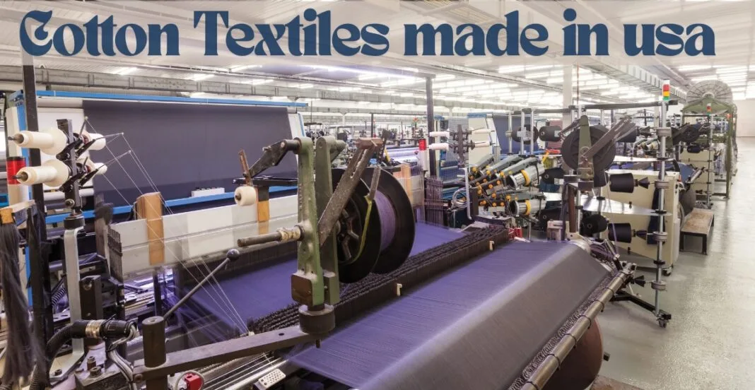 Interior view of a textile manufacturing plant with machinery producing cotton fabrics, with a large sign overhead that reads 