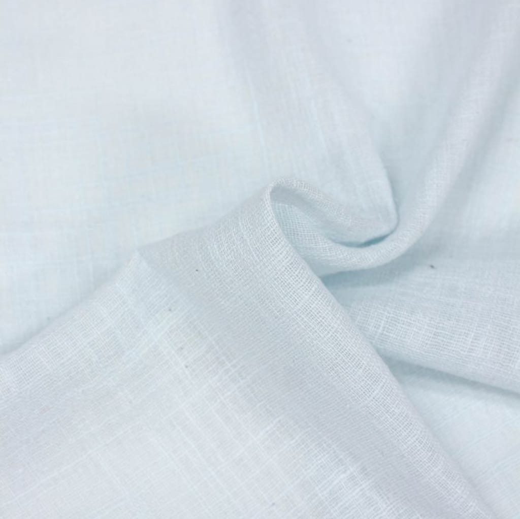 Close-up image of light-colored, semi-sheer cotton voile fabric with a soft, smooth, and slightly textured surface, gently folded to show its lightweight and airy quality.