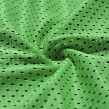 A close-up image of bright green brushed polyester fabric with a textured, slightly fuzzy appearance and small black perforations.