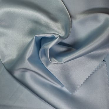 Close-up image of light blue satin polyester fabric with a smooth, shiny surface and soft folds.