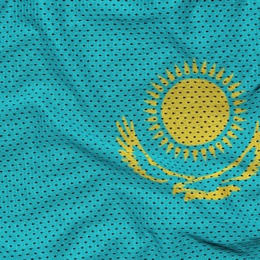 Close-up of blue moisture-wicking polyester mesh fabric with small perforations for breathability.