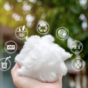 A person holding a piece of fluffy white recycled polyester fabric outdoors, with various eco-friendly icons (recycling, sustainability, PET plastic, and eco watch) floating above, emphasizing sustainable and recycled materials.