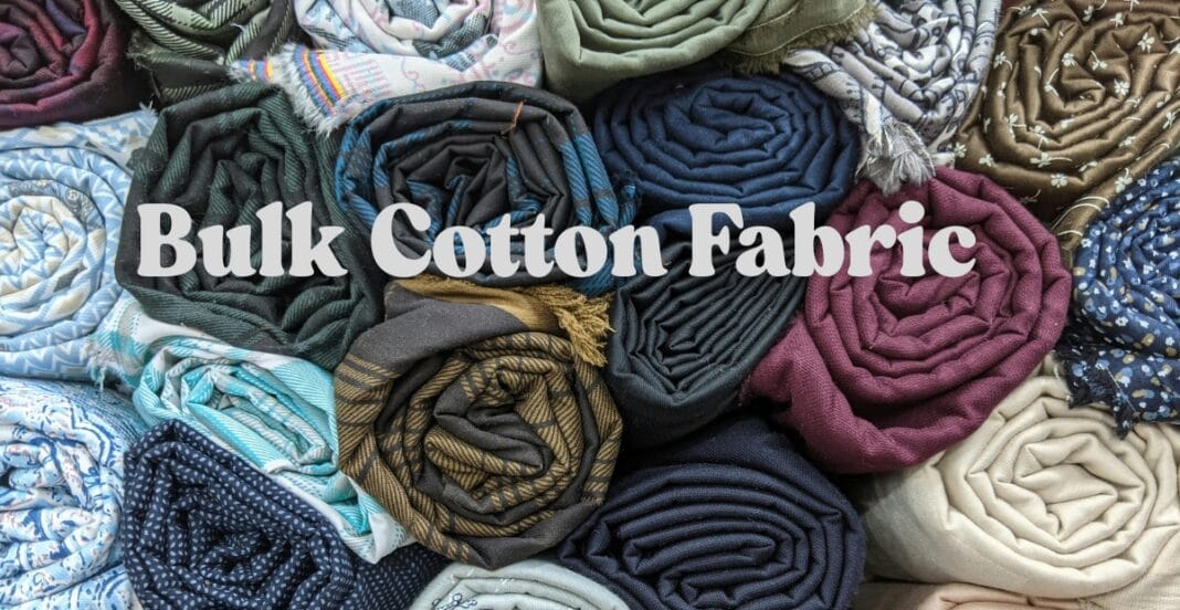 Rolled and folded bulk cotton fabrics in various colors and patterns arranged together.