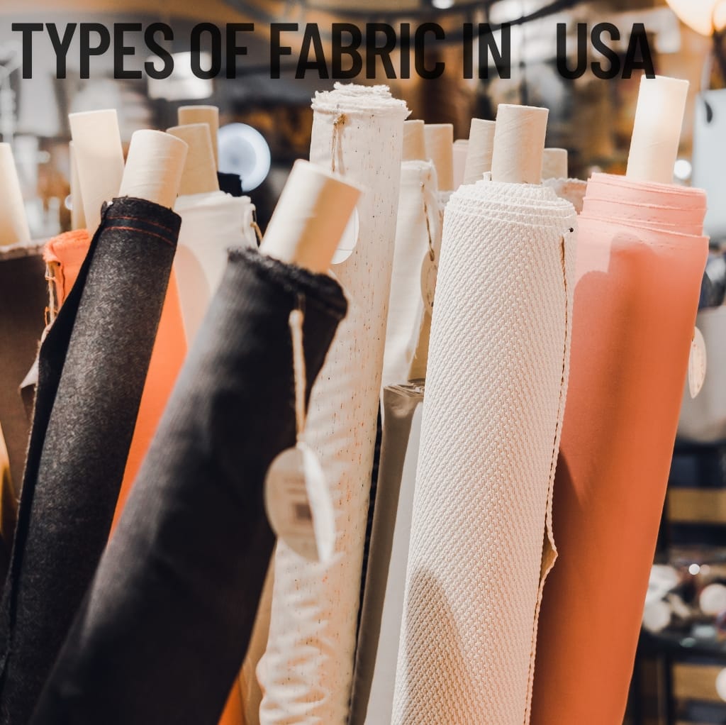 A close-up image of various fabric rolls in different colors and textures, displayed vertically. The background is blurred, and the text "TYPES OF FABRIC IN USA" is overlaid at the top of the image. Cloth Made in USA