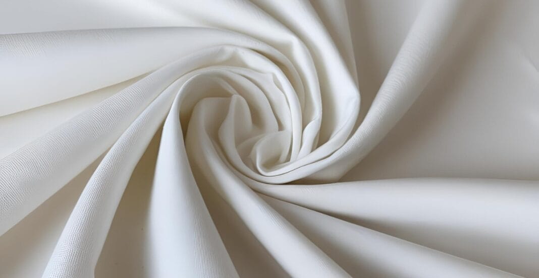 Close-up of smooth, white cotton fabric in a spiral shape.