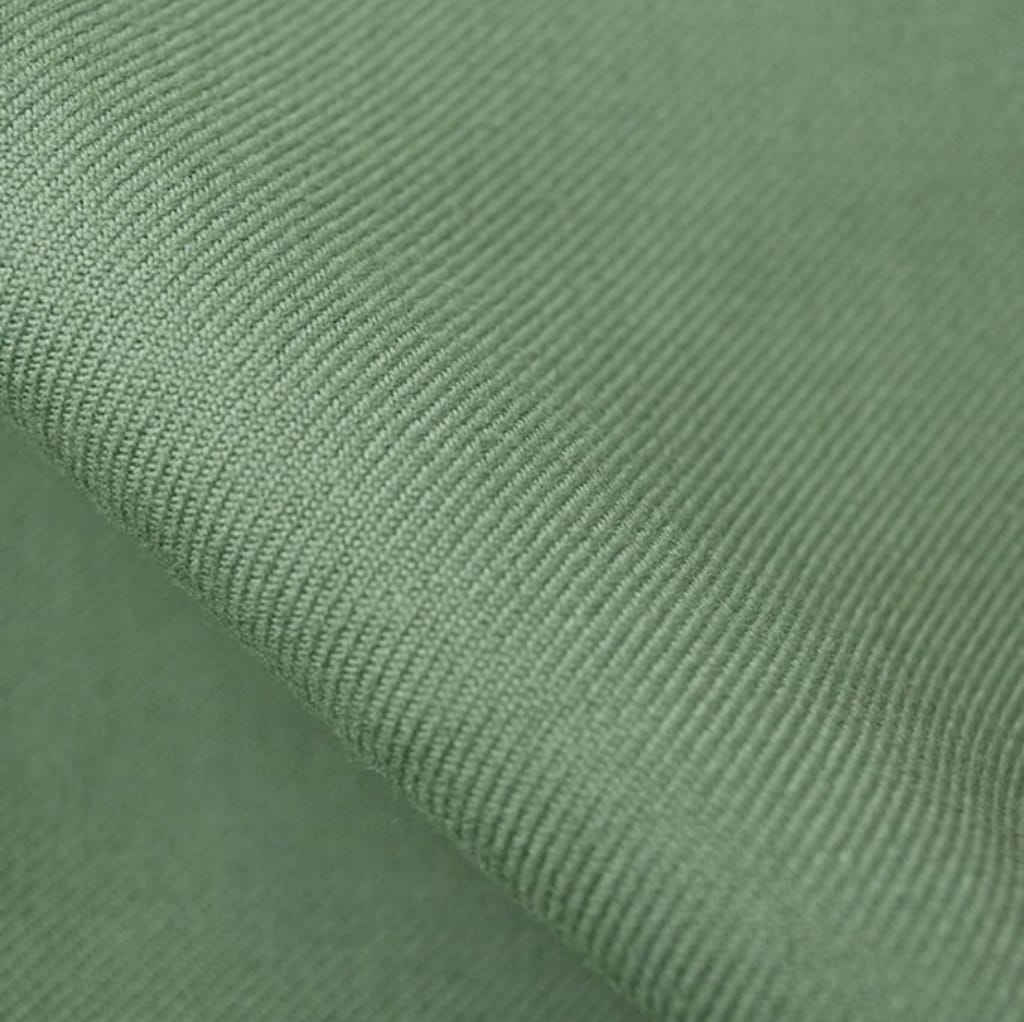Close-up image of green twill cotton fabric showing the diagonal weave pattern.