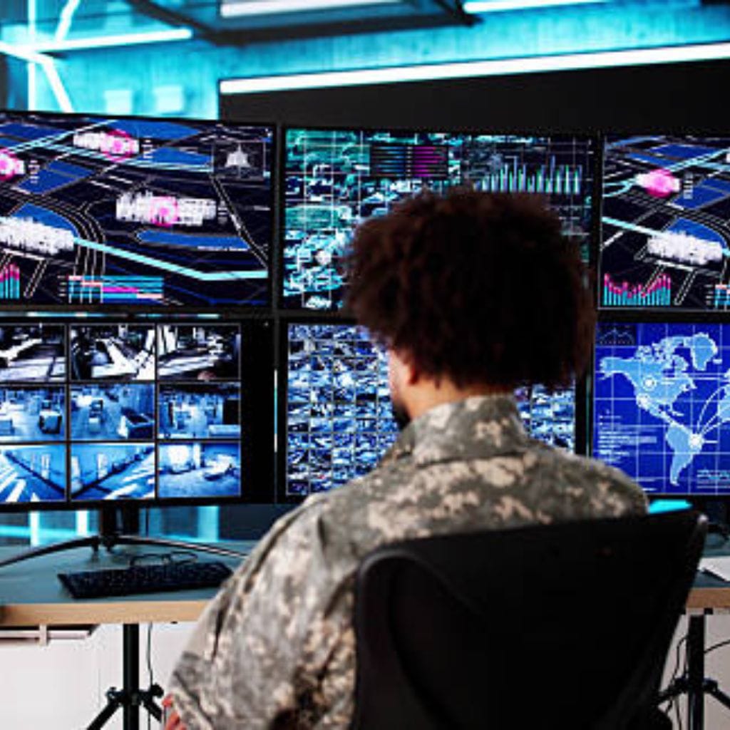 Person in military-style uniform monitoring global data and security feeds – Write for Us Technology.