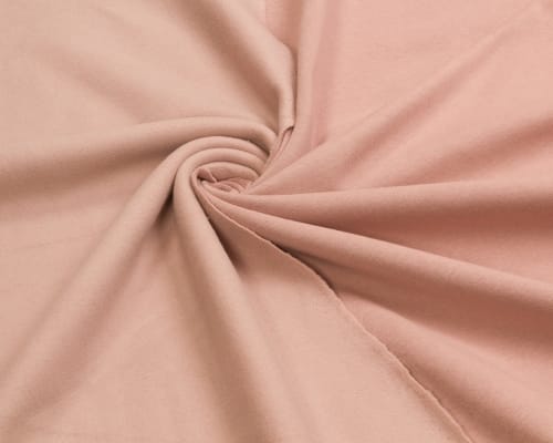 Soft, blush pink cotton fabric twisted into a swirl, showcasing smooth texture and gentle draping.