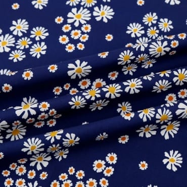 A close-up image of a printed polyester fabric featuring a pattern of white daisies with yellow centers scattered across a dark blue background.