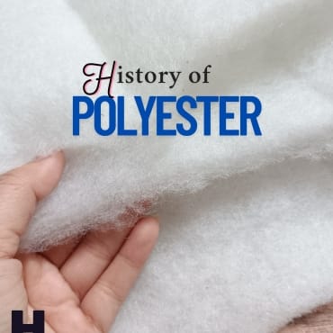 Close-up of a hand holding a piece of white polyester fabric with the text "History of Polyester" overlaid, featuring “History of” in a script font and “POLYESTER” in bold blue letters.