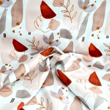 Close-up of printed polyester fabric featuring abstract leaves and shapes in earthy tones like rust, beige, grey, and white, with a soft, smooth texture.