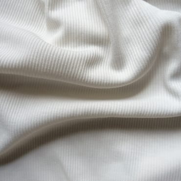Close-up of soft, ribbed white polyester fabric, showing a comfortable, cozy texture.