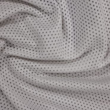 Close-up of soft, light-colored polyester mesh fabric with small, evenly spaced black dots.