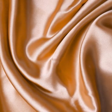 Shiny, smooth, golden-brown PET polyester fabric with soft folds.