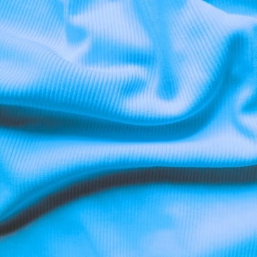Close-up of a bright blue polyester rib knit fabric with soft, evenly spaced ridges.