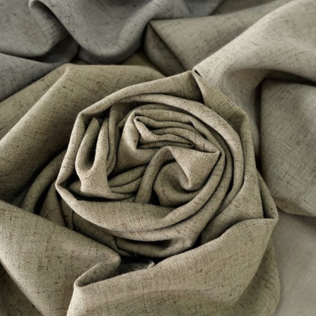 A close-up photograph of beige linen fabric arranged in a way that it forms spiral and folds, creating a textured and layered appearance.