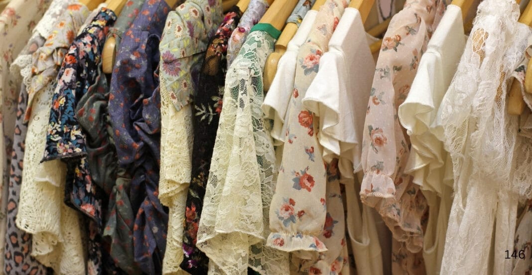 A row of cotton babydoll dresses hanging on a rack, featuring various floral, lace, and patterned designs in soft, light colors.