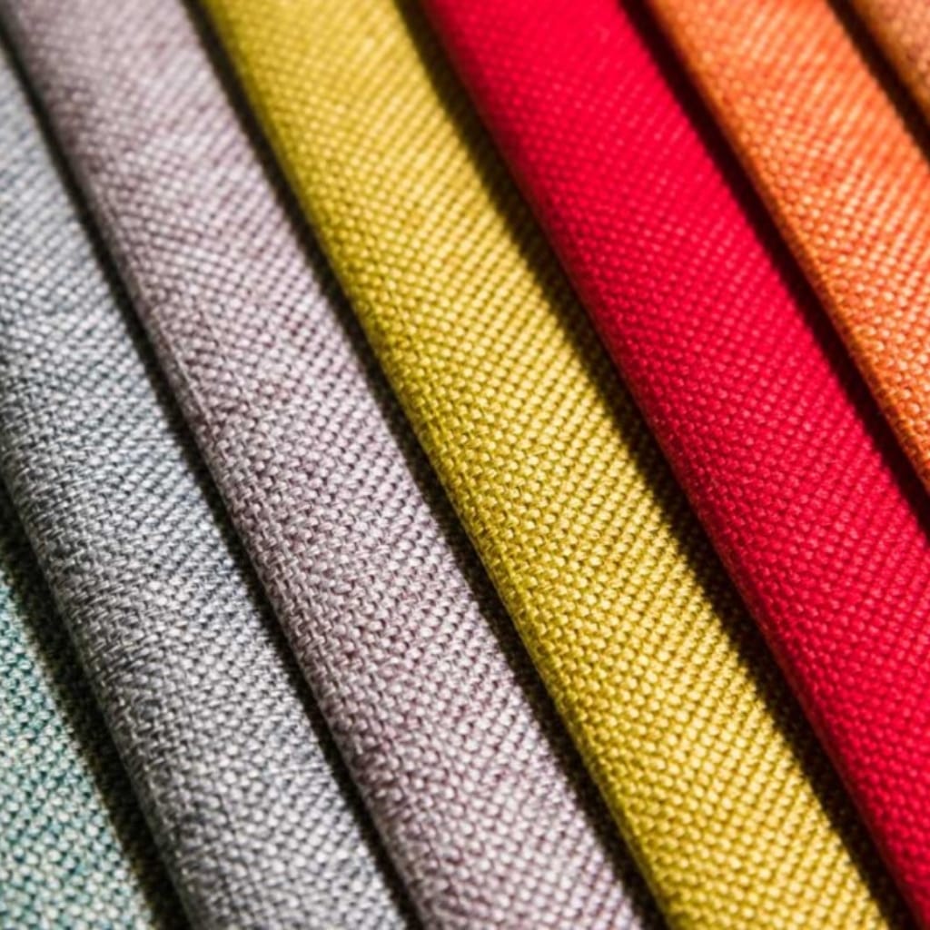 Close-up of colorful fabric rolls with textured surfaces, arranged diagonally.