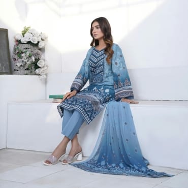 Elegant woman sitting on a white bench wearing a beautifully embroidered blue chiffon outfit with matching shawl for special occasions.