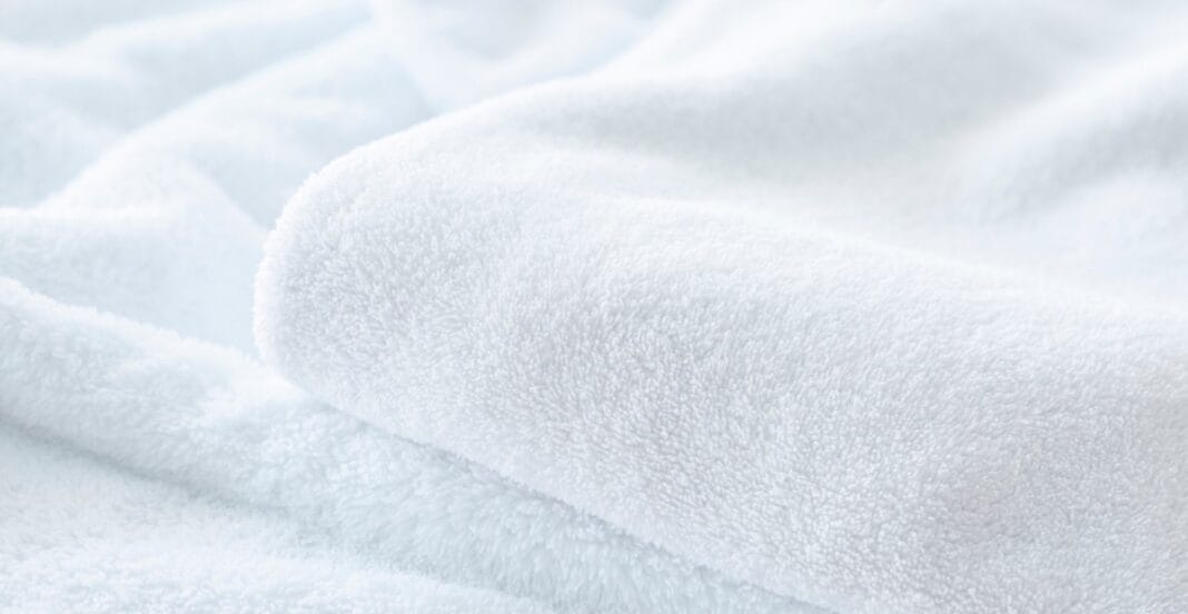 Close-up image of soft, white fleece fabric with a plush, textured surface.