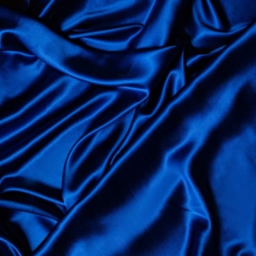 Close-up image of deep blue velvet spandex fabric with smooth, shiny, and slightly stretched appearance.