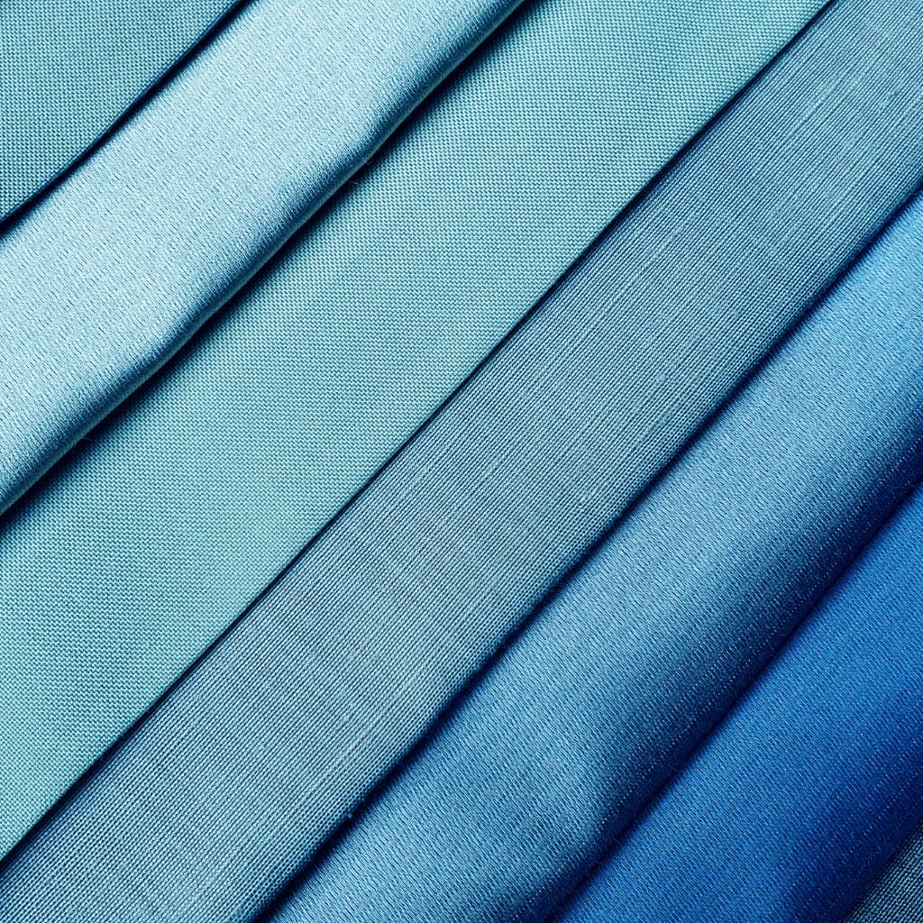 Close-up image of neatly folded, shiny blue nylon organza fabric showcasing its smooth, crisp texture and vibrant color.