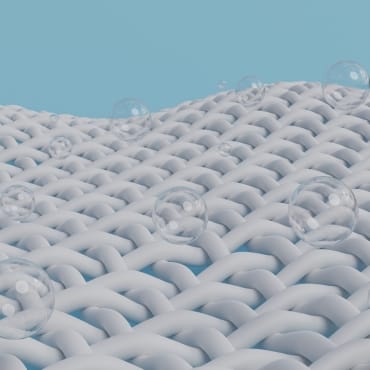 Close-up of white woven mesh fabric with small, evenly spaced holes and transparent bubbles on its surface.