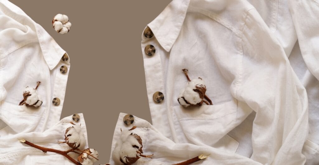 Two white shirts with cotton stems attached to the pockets and buttons, set against a taupe background.