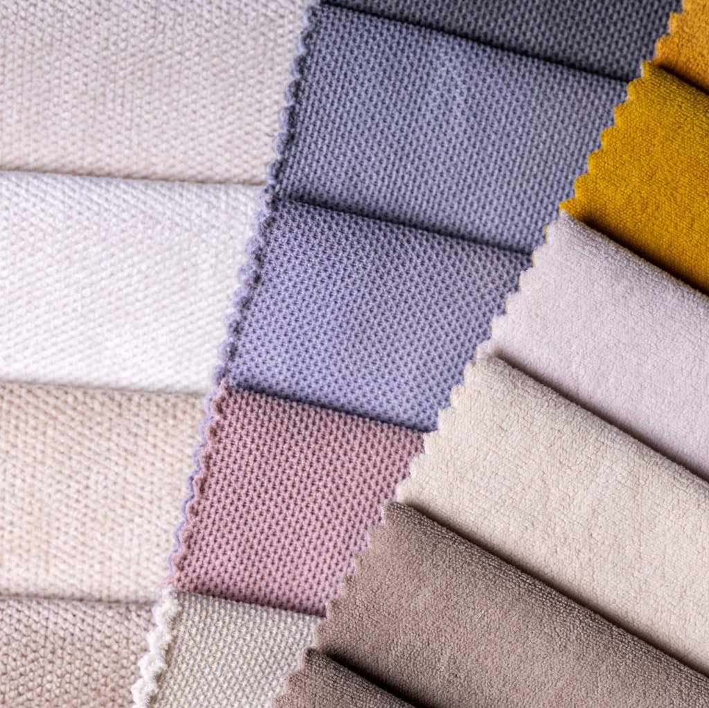 A close-up of various fabric swatches in different colors and textures, showcasing a range of textiles suitable for different seasons.