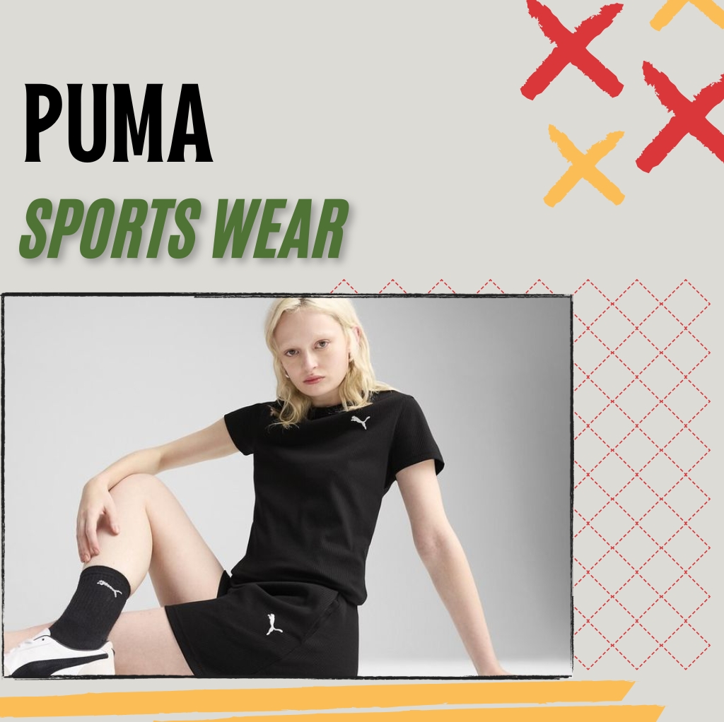 A young woman is sitting on the floor against a neutral background, wearing black Puma sportswear including a t-shirt, shorts, socks, and sneakers, with a serious expression.