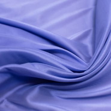 Vibrant purple rayon chiffon fabric with soft folds and a smooth, semi-sheer texture.